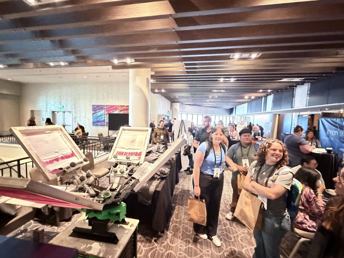 Convention crowd gathered around a live merch printing booth